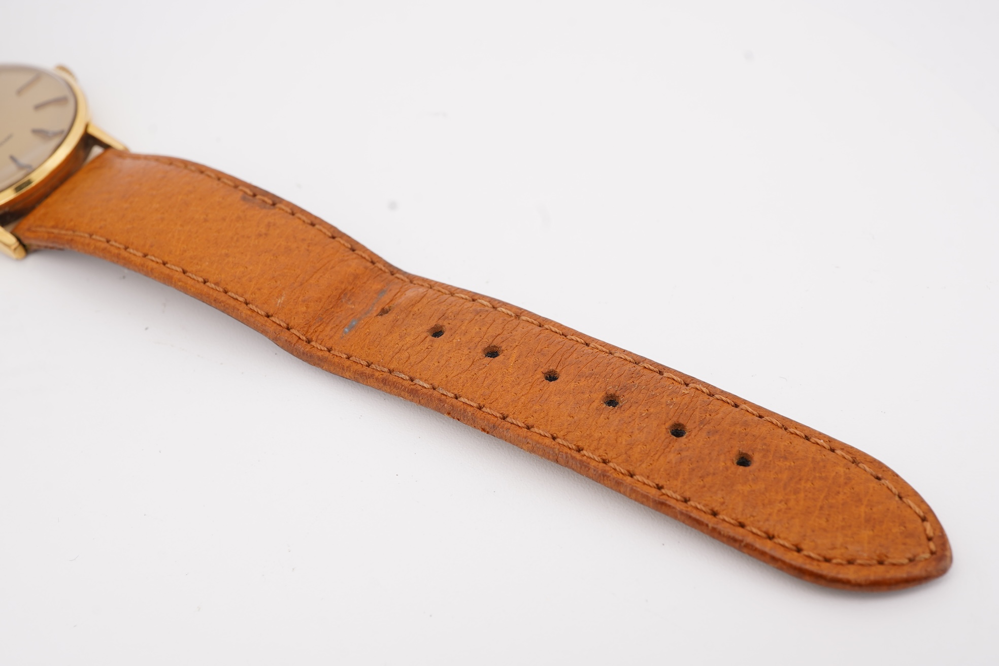 A gentleman's steel and gold plated Bulova Longchamp manual wind wrist watch, with baton numerals, case diameter 33mm, on a tanned leather strap.